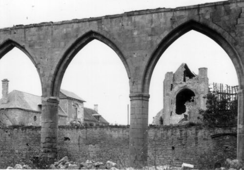Vers 1946, l’église et la porte Saint-Norbert vues au travers des arcades de la grange aux dîmes, s.d., Médiathèque de l’architecture et du patrimoine.